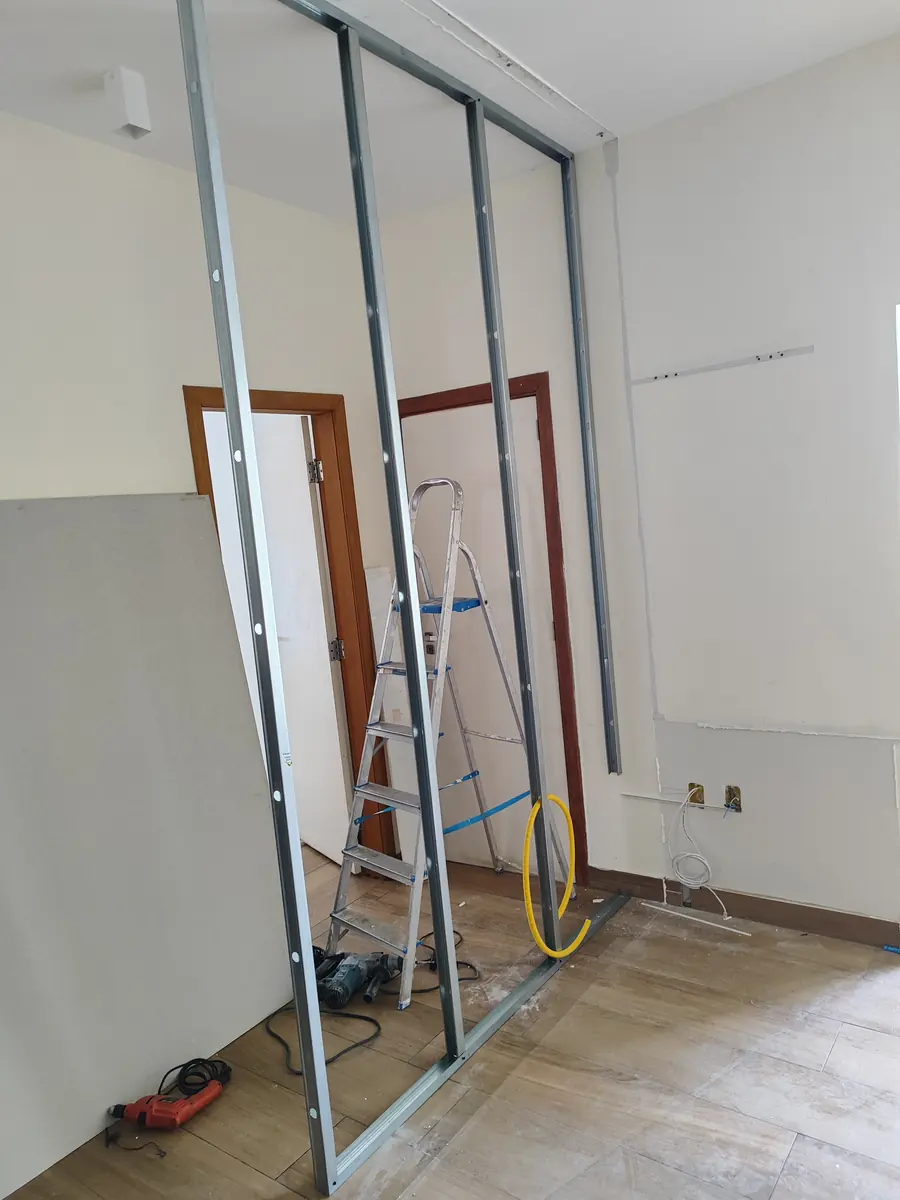 Estrutura de montantes de uma divisória montada no meio da sala